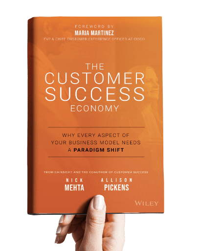 A hand holding the Customer Success Economy book